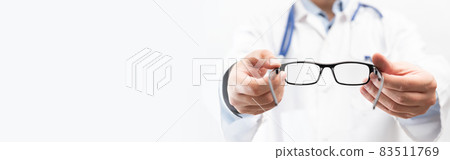Optometrist holds glasses to try on Optometrist holds glasses to try on 83511769