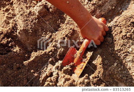 Children's hands and shovel playing in the sandbox 83513265