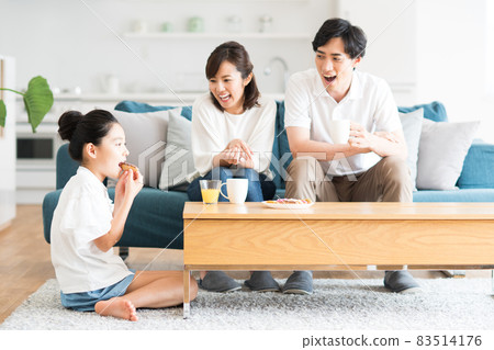 一個在客廳裡放鬆的年輕家庭 83514176