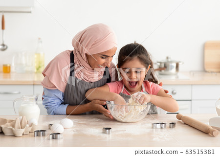 Little Arab Girl Kneading Dough While Baking With Muslim Mom In Kitchen 83515381