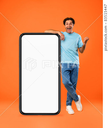 Yes. Man leaning on white empty smartphone screen celebrating success 83515447