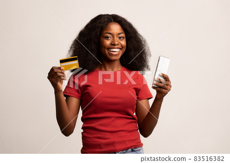 Mobile Banking. Happy Beautiful African American Woman Holding Smartphone And Credit Card Mobile Banking. Happy Beautiful African American Woman Holding Smartphone And Credit Card 83516382