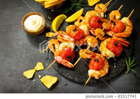 Delicious Grilled shrimps with spice, lemon and sauce served on a slate board served with nachos chips. Seafood. Top view flat lay background. Free space for your text. 83517741
