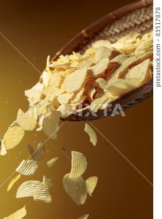 Falling potato chips on a yellow background. Falling potato chips on a yellow background. 83517878