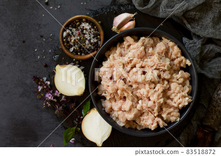 Minced meat and ingredients for cooking minced meat in a bowl on a slate. Top view. 83518872