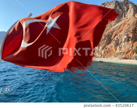 Turkish flag on the background of the sea and mountains in sunny weather 83520617