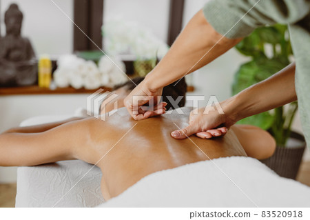 African American woman having back massage in modern spa salon. 83520918