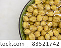 Chickpeas soaked in water, in bowl, on marble table. Concept of healthy eating, veganism, vegetarianism, meat and egg replacement. Prepare chickpeas before making hummus and other legume dishes 83521742