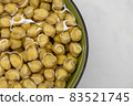 Chickpeas soaked in water, in bowl, on marble table. Concept of healthy eating, veganism, vegetarianism, meat and egg replacement. Prepare chickpeas before making hummus and other legume dishes 83521745
