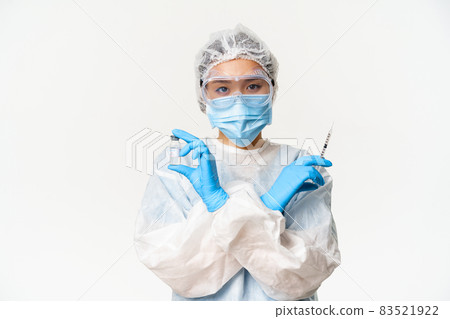Covid-19 vaccination and health concept. Asian female doctor or nurse in personal protective equipment from coronavirus, showing vaccine covid-19 and syringe, white background 83521922