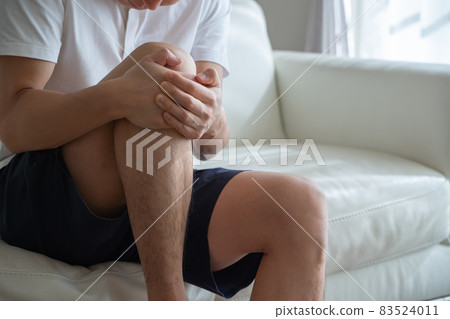 A man holding his knees A man holding his knees 83524011