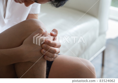 A man holding his knees 83524062