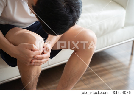 A man holding his knees 83524086