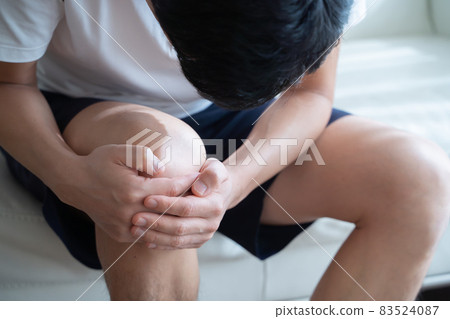 A man holding his knees 83524087