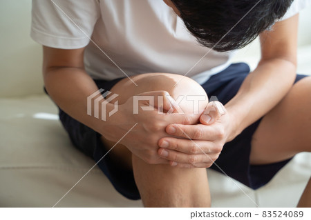A man holding his knees 83524089
