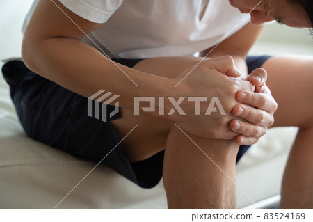 A man holding his knees 83524169