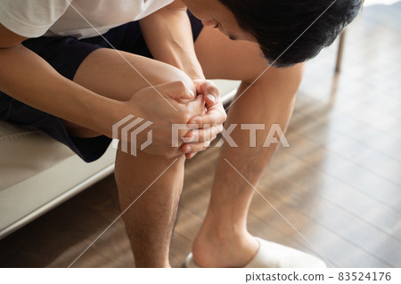 A man holding his knees A man holding his knees 83524176