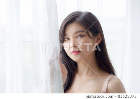 Beautiful portrait young asian woman sexy standing the window and smile while wake up with health. Beautiful portrait young asian woman sexy standing the window and smile while wake up with health. 83525375