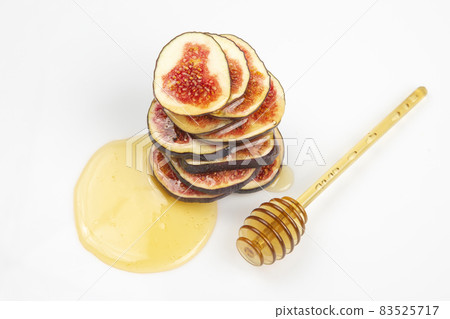 figs cut into pieces and drizzled with honey on a white plate. vitamin organic healthy food figs cut into pieces and drizzled with honey on a white plate. vitamin organic healthy food 83525717