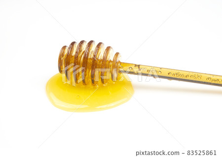 spoon with fresh honey spilled on a white background. organic vitamin food spoon with fresh honey spilled on a white background. organic vitamin food 83525861