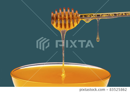 fresh fragrant honey dripping from a spoon into a plate. organic vitamin nutrition 83525862