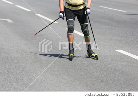 sportsman roller skis on the asphalt on the city road. Sports leisure sportsman roller skis on the asphalt on the city road. Sports leisure 83525895
