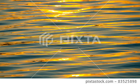 Reflection of the setting sun in a wave of water. Natural background texture Reflection of the setting sun in a wave of water. Natural background texture 83525898