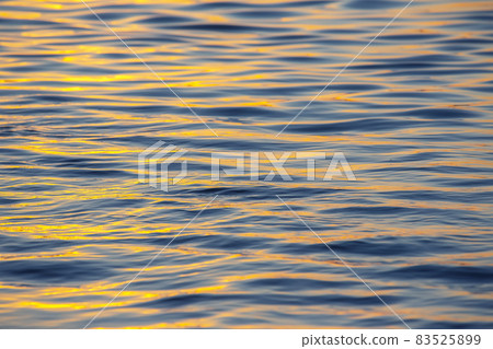 Reflection of the setting sun in a wave of water. Natural background texture Reflection of the setting sun in a wave of water. Natural background texture 83525899