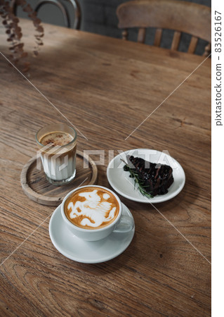 Latte art coffee on wooden table in coffee shop 83526167