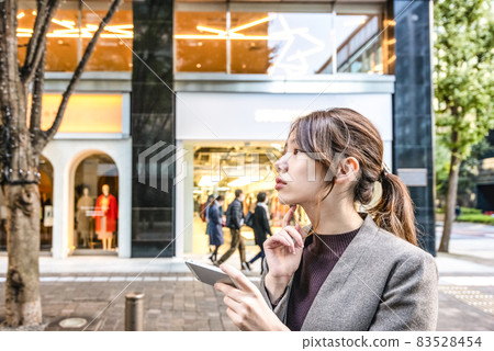 在東京丸之內操作智能手機的表情嚴肅的年輕女子 83528454