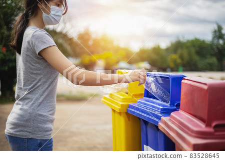 woman wearing mask hand holding bottle plastic garbage into trash in park woman wearing mask hand holding bottle plastic garbage into trash in park 83528645