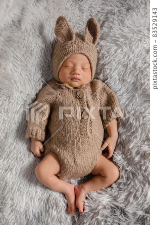 happy newborn baby weaing cute rabbit costume lying sleep on grey carpet background comfortable and safety.Cute Asian infant sleeping and napping on baby bed.Newborn Baby Easter Day Concept happy newborn baby weaing cute rabbit costume lying sleep on grey carpet background comfortable and safety.Cute Asian infant sleeping and napping on baby bed.Newborn Baby Easter Day Concept 83529143