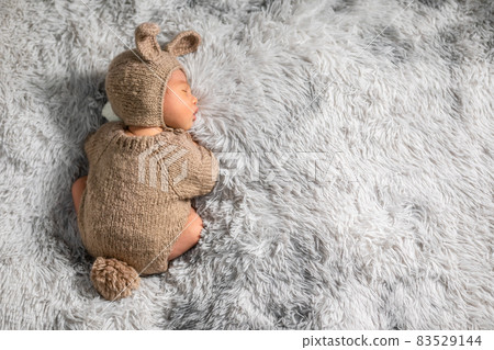 Back view happy newborn baby weaing cute rabbit costume lying sleep on grey carpet background comfortable with copy space.Cute Asian infant sleeping napping on baby bed.Newborn Baby Easter Day Concept Back view happy newborn baby weaing cute rabbit costume lying sleep on grey carpet background comfortable with copy space.Cute Asian infant sleeping napping on baby bed.Newborn Baby Easter Day Concept 83529144