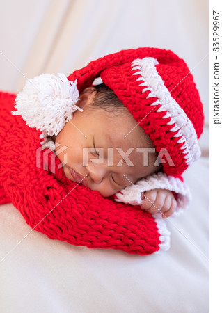 Cute Newborn baby wearing santa costume lying and sleep waiting for celebrate merry christmas and happy new year.Calm of infant baby sleep with red santa cloth 83529967