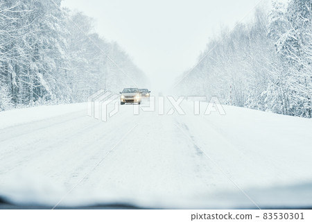 Snowy road in winter forest with moving car Snowy road in winter forest with moving car 83530301