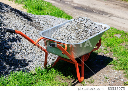 Wheelbarrow with gravel at the construction site Wheelbarrow with gravel at the construction site 83532075