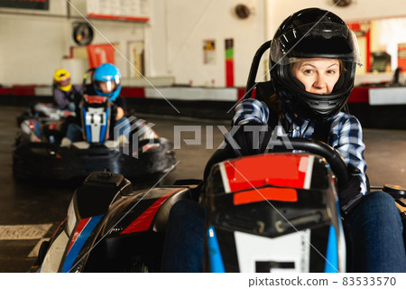 woman driving racing car at kart circuit 83533570