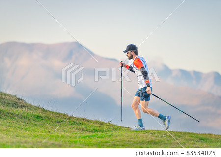 Athlete practicing Nordic walking in the hills Athlete practicing Nordic walking in the hills 83534075