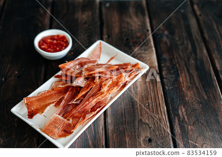 Dried chicken cut into strips on a wooden board with salt, pepper, adjiga, ketchup Dried chicken cut into strips on a wooden board with salt, pepper, adjiga, ketchup 83534159