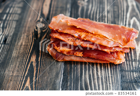 Dried chicken cut into slices on a wooden board Dried chicken cut into slices on a wooden board 83534161