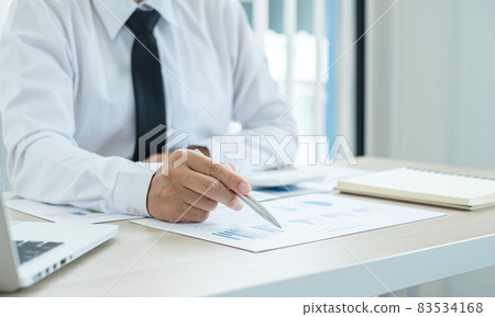 The businessman hand sits at their desks and calculates financial graphs showing the results of their investments planning the process of successful business growth The businessman hand sits at their desks and calculates financial graphs showing the results of their investments planning the process of successful business growth 83534168