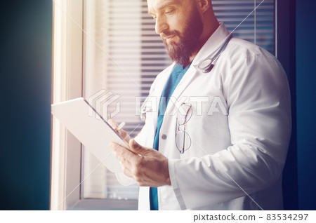 Doctor examines information and writes a prescription online with modern technology 83534297