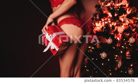 sexy ass of a girl in underwear with a gift box in her hands at the Christmas tree on New Year sexy ass of a girl in underwear with a gift box in her hands at the Christmas tree on New Year 83534576
