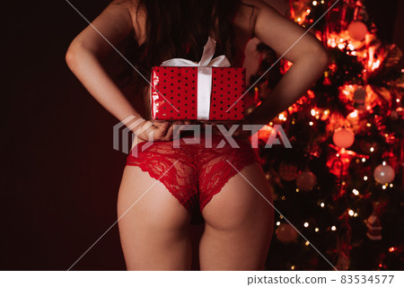 sexy ass of a girl in red panties with a gift in her hands next to the Christmas tree at the new year sexy ass of a girl in red panties with a gift in her hands next to the Christmas tree at the new year 83534577