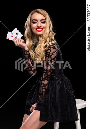 Beautiful confident woman sitting on chair showing cards looking at camera with copy place 83535097