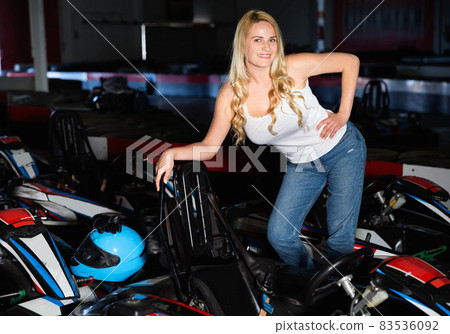 Sexy woman standing near sport cars for karting in sport club Sexy woman standing near sport cars for karting in sport club 83536092
