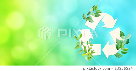 Arrows recycle symbol and green leaves on blurred background of green and blue colors Arrows recycle symbol and green leaves on blurred background of green and blue colors 83536584