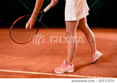 From above legs of tennis woman on court with racket 83537074