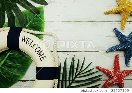 Summer concept with green leave, starfish and lifebuoy decoration on wooden background Summer concept with green leave, starfish and lifebuoy decoration on wooden background 83537399