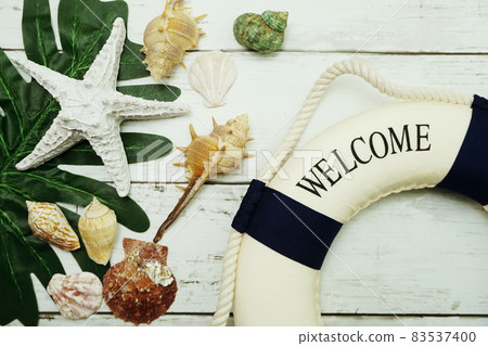 Summer concept with green leave, starfish and lifebuoy decoration on wooden background Summer concept with green leave, starfish and lifebuoy decoration on wooden background 83537400